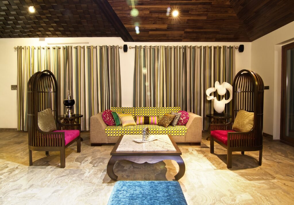 Elegant living room featuring colorful sofa and unique chairs with vibrant decor.