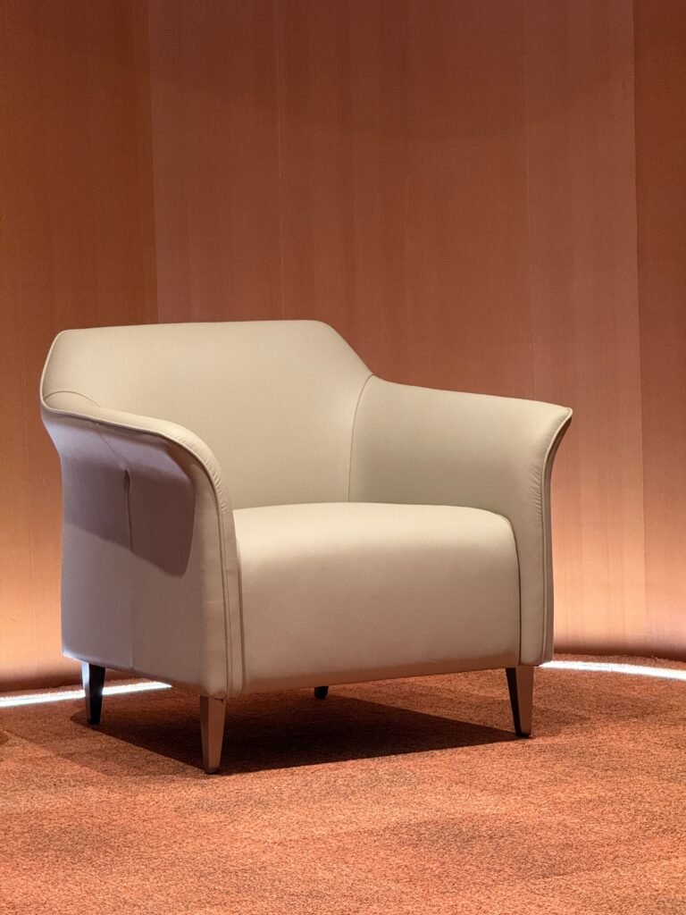 Elegant beige armchair in a minimalist, warm-toned interior.