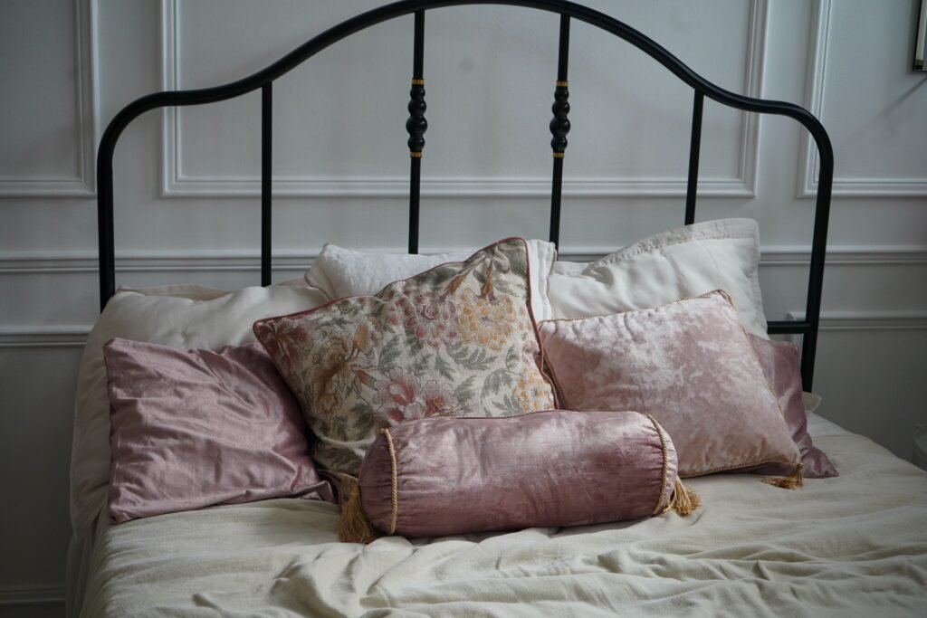 A cozy and elegant bedroom setup featuring decorative cushions and a classic bed.